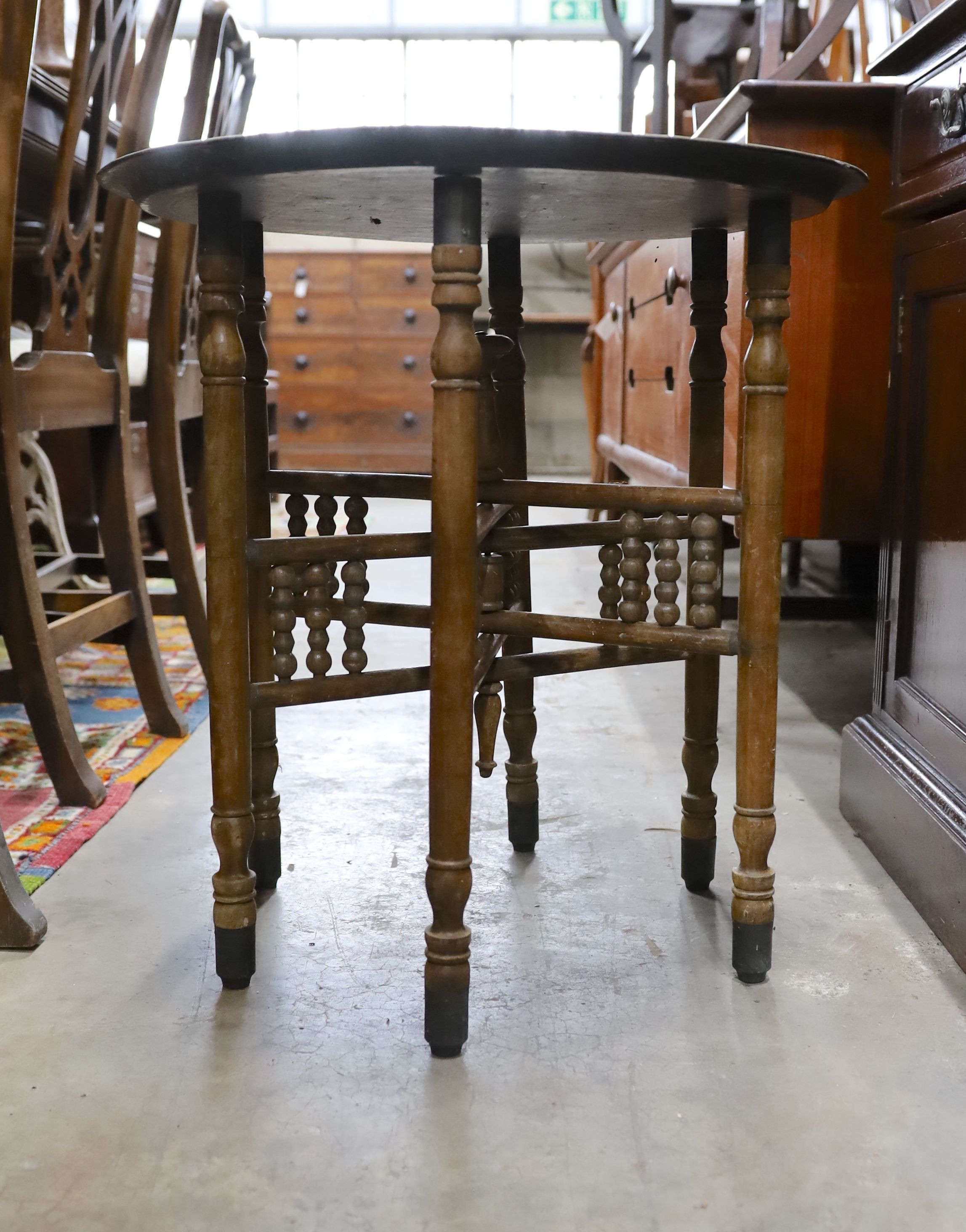 An Indian engraved brass circular tray top folding table, diameter 58cm, height 50cm